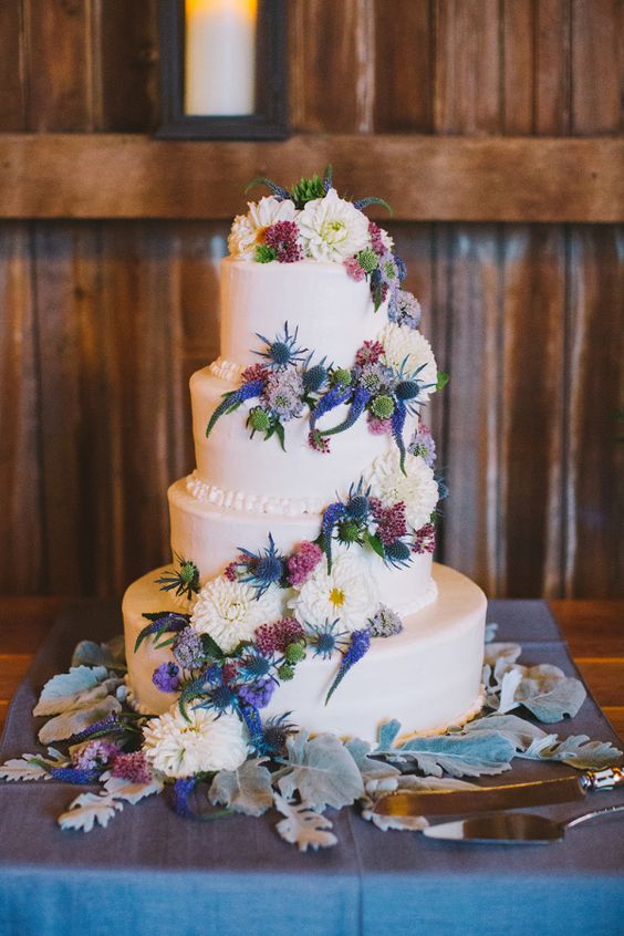 Colorful floral topped wedding cake via Alexandra Meseke